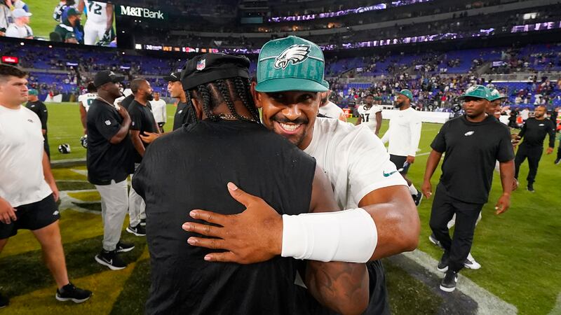 Baltimore Ravens quarterback Lamar Jackson, middle left, hugs Philadelphia Eagles quarterback...