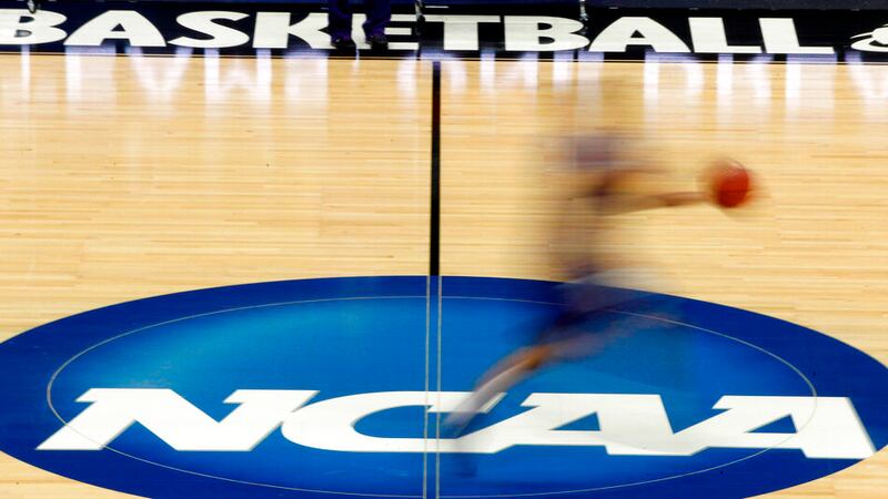 In this March 14, 2012, file photo, a player runs across the NCAA logo during practice in...