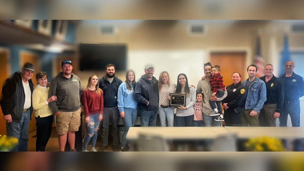 DoorDash driver Sophia Furtado, holding plaque, was honored for saving the life of Caryn...